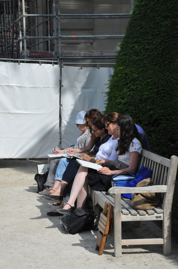 Tinha um grupo de estudantes reproduzindo no caderno as esculturas do jardim